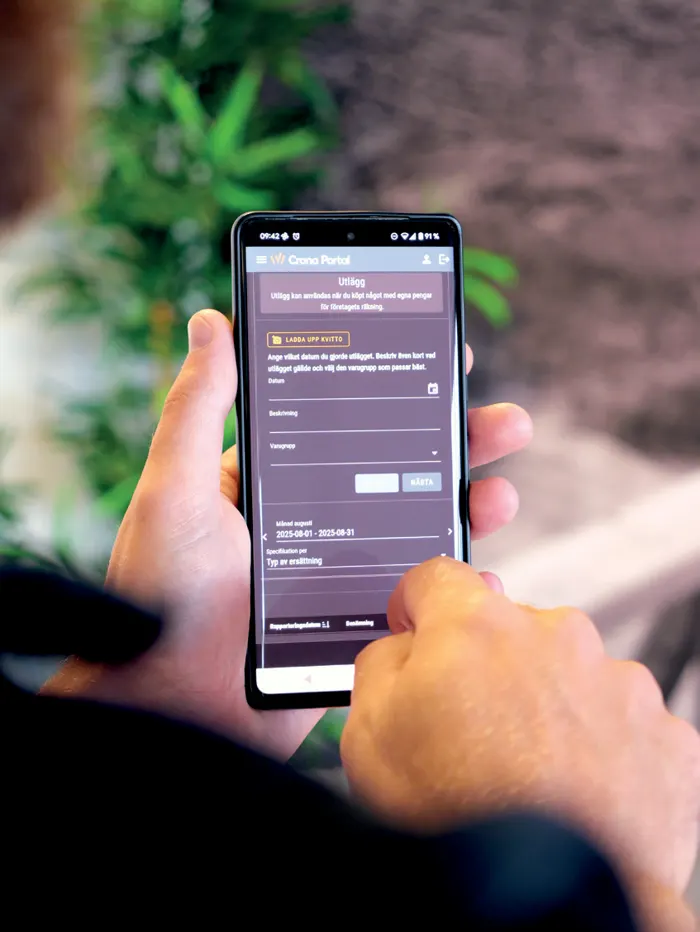 Crona Portal i en mobil som hålls i handen