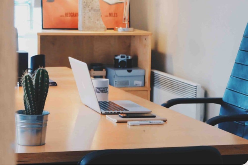 Laptop på skrivbord framför tom stol